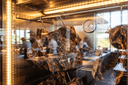 Yaz sıcağında çalışan dry aged et dinlendirme dolabının içinde kancalarda asılı dana etleri