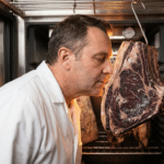 Kasap, dry aged dolabında asılı dinlendirilmiş antrikot loinunun kokusunu kontrol ediyor