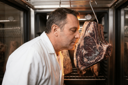 Kasap, dry aged dolabında asılı dinlendirilmiş antrikot loinunun kokusunu kontrol ediyor