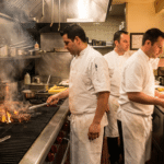 Steakhouse mutfağında ızgara istasyonunda çalışan aşçı ekibi