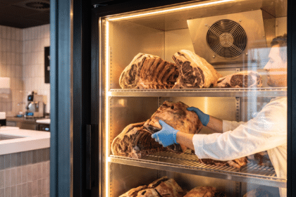 Kasap, dry aged dolabında bir et parçasını alt raftan üst rafa alarak konum rotasyonu yapıyor